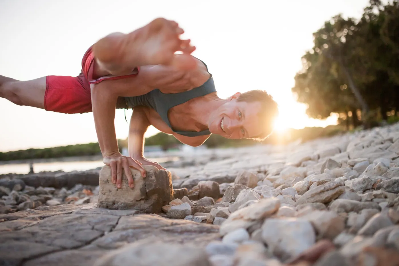 Mito balancing on a rock at a beach at sunset